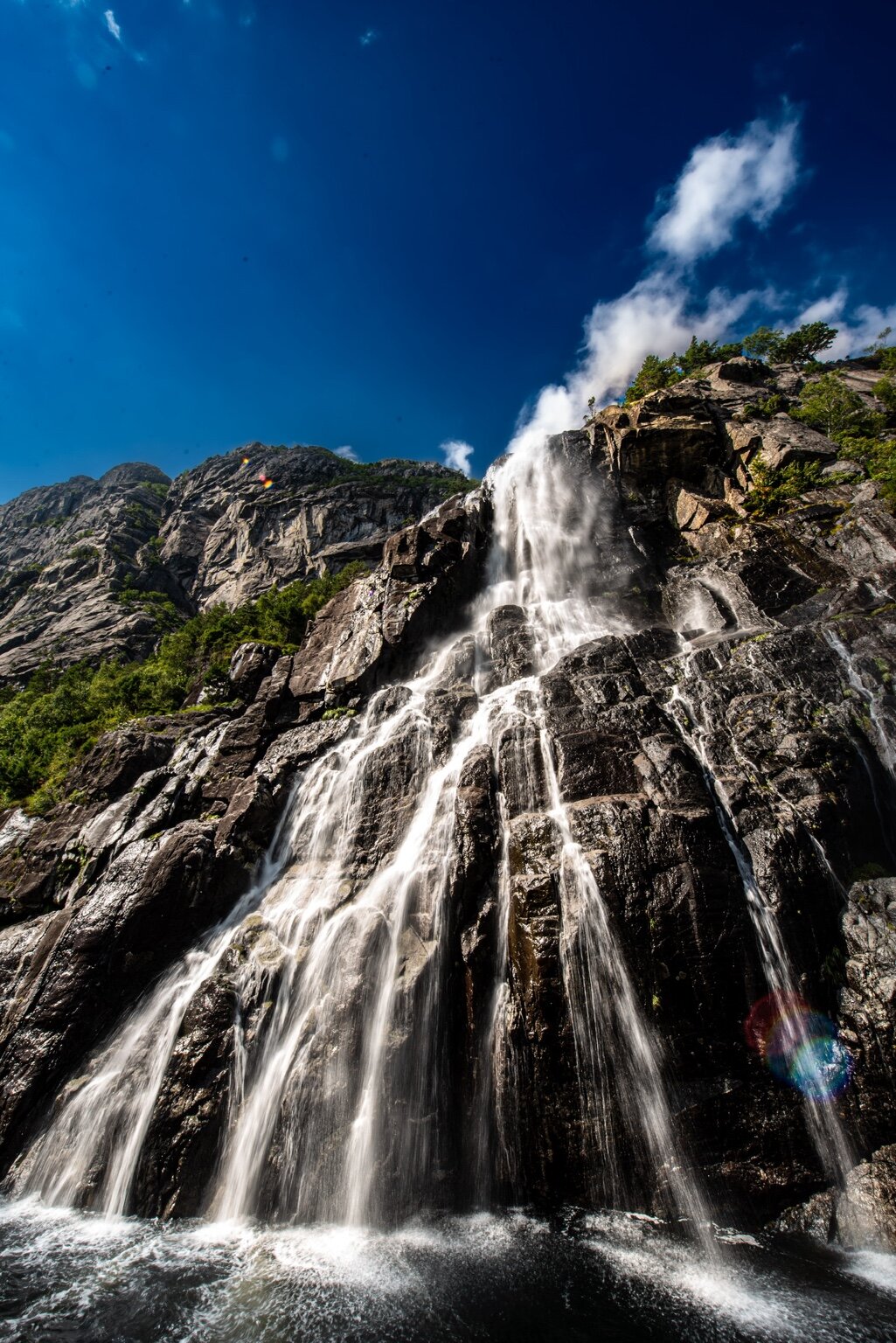 Mountain waterfall beneath a blue sky