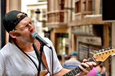 Street musician singing and playing guitar